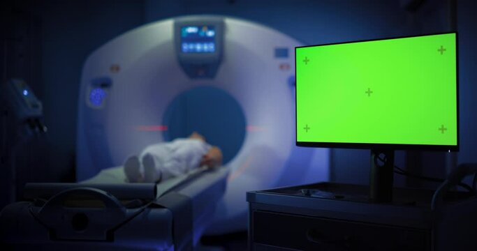 Medium Shot of a Female Patient Undergoing Brain Scan in a CT or MRI High-Tech Equipment. Display Monitor Showing Green Screen Mockup Template. Footage In Medical Laboratory or Healthcare Facility