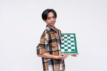 A young asian man with side-parted hair holding a chess board. Isolated on a white background.