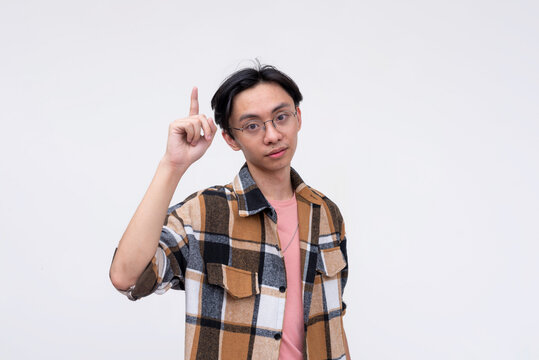 A pensive young asian man giving tips and reminders. Isolated on a white background.