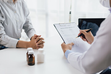 Doctor diagnosing a woman's illness in a hospital examination room, drug treatment from specialized...
