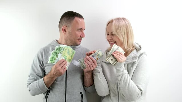 a middle-aged wife asks her husband for money to buy dollars and euros, the husband takes part of it, wife, pouting her lips, hides money in her bosom, laughs, smiles, flirts, the husband hid dollars