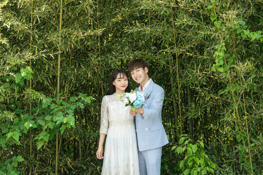 A loving couple is taking wedding photos outdoors for their wedding.