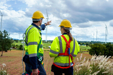 Two engineers plan on-site inspection and maintenance of wind turbines