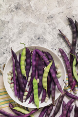 Plate with freshly picked purple bean pods. Top view. Copy space.