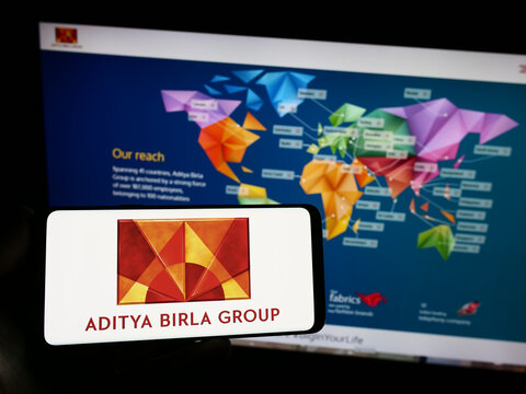 Stuttgart, Germany - 09-06-2023: Person holding smartphone with logo of Indian company Aditya Birla Group (ABG) on screen in front of website. Focus on phone display.
