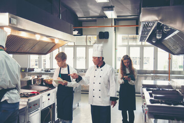 the group children in class kitchen room. Chef preparing student for learning marking and cooking...