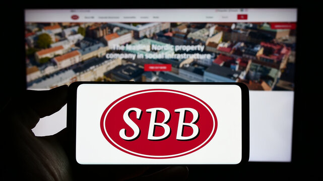 Stuttgart, Germany - 09-06-2023: Person holding smartphone with logo of Samhallsbyggnadsbolaget i Norden AB (SBB) on screen in front of website. Focus on phone display.
