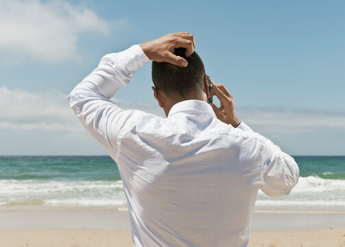 A Businessman On The Beach Talking On His Cell Phone; Tarifa, Cadiz, Andalusia, Spain