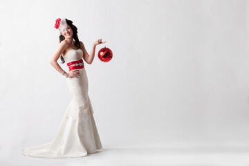 Portrait Of A Young Woman Wearing A White Strapless Formal Dress With Red Accessories Against A White Background; Nashville, Tennessee, United States of America