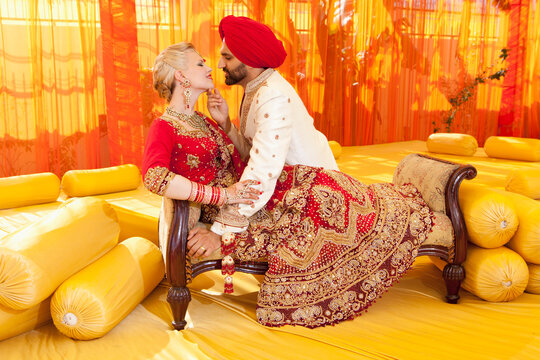 A Bride And Groom In Traditional Indian Dress For Their Wedding Ceremony; Ludhiana, Punjab, India