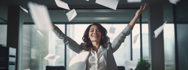 Happy businesswoman throwing papers in the air as a sign of victory and success in her work - obrazy, fototapety, plakaty