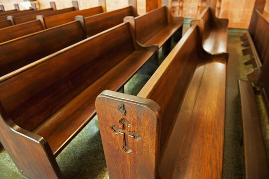 Wooden pews in a church with crosses etched into the ends; New orleans mississippi united states of america
