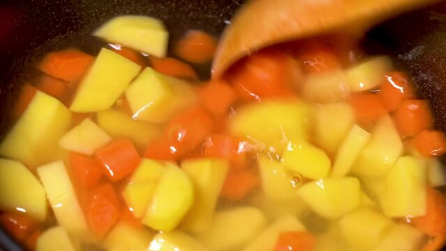 carrots and potatoes are boiled in a saucepan