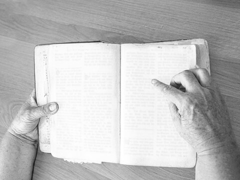 hands holding an open old book, mockup, top view, mockup for design, black and white photo