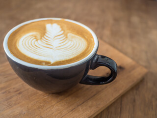 beautiful latte art coffee in a black cup