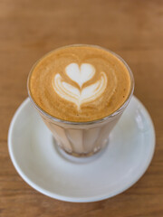 latte art tulip trait in a glass on wooden table