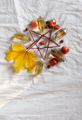 Crystal minerals and autumn maple leaf on light fabric background. autumn composition. mandala for...