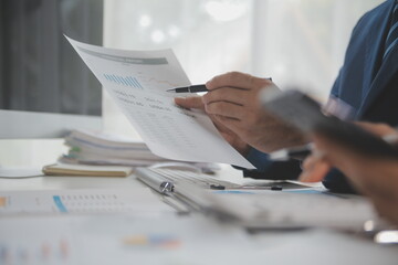 Financial analysts analyze business financial reports on a digital tablet planning investment project during a discussion at a meeting of corporate showing the results of their successful teamwork.