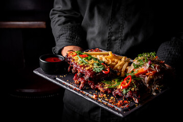 chef or waiter hold Pork ribs with french fries and coleslaw salad 