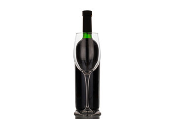 One bottle of red wine with glass goblet, macro, isolated on white background.