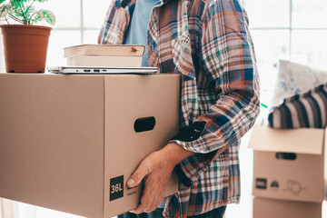 Close-up on senior man involved in moving house moving cardboard boxes, concept of relocation,...