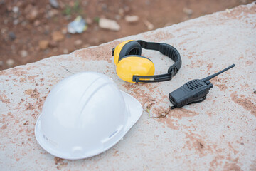 Mechanic's equipment, white protective hat Black walkie talkie and hearing protection headphones