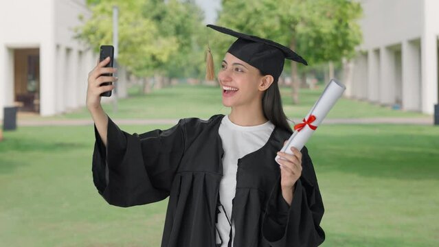 Happy Indian college graduate girl clicking selfies