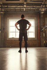 Sport is my lifestyle. Back view of young athletic man in sportswear standing at gym before training
