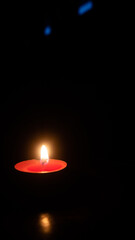 a burning candle against a dark background