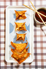 Fried wontons with soya sauce on a vibrant colorful background - 647763620