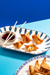 Fried wontons with soya sauce on a vibrant colorful background - 647763637