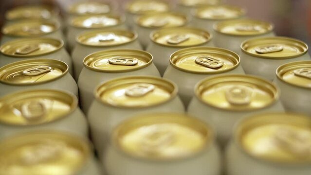 Shopping at the supermarket. A woman buying beer in cans. Close-up.
