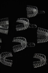 Reusable plastic impression trays on a black background. Transparent trays for dental impressions.
