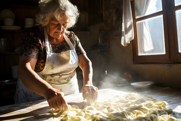 Senior Italian woman in the process of making pasta in a village house kitchen, concept of Italian cuisine, traditional cooking, family traditions and the art of making homemade pasta.