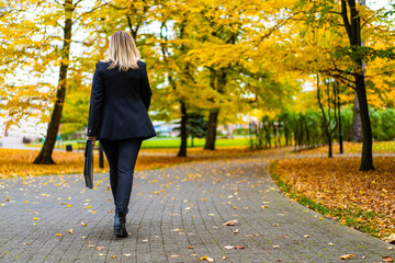Beautiful businesswoman walking in city park
