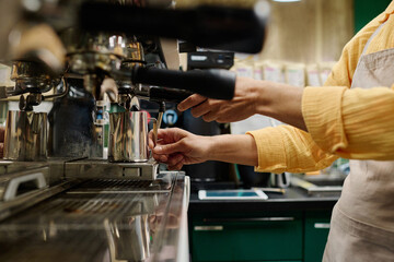 Close-up of female bartender making coffee from coffee machine in supermarket