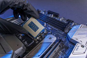 computer processor in a gloved hand against the background of the motherboard