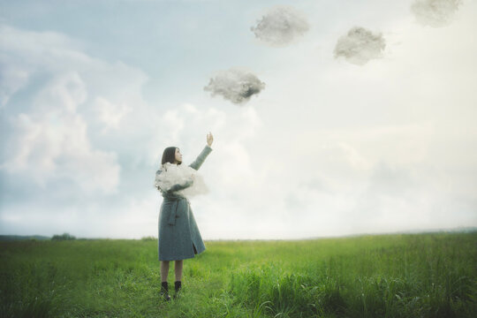 woman is releasing the clouds that she was holding in her arms into the sky, abstract concept