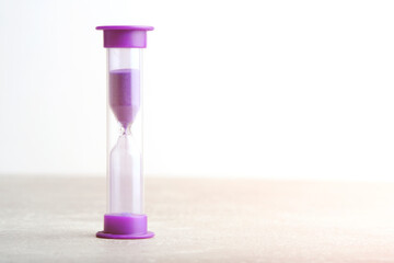 Hourglass for one minute purple on light background.