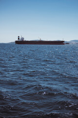 Nave porta container al largo dello stretto di Gibilterra, sullo sfondo le montagne del Marocco