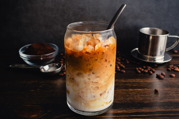Vietnamese Yogurt Coffee (Sua Chua Cafe or Cà Phê Sữa): A glass of iced Vietnamese coffee with strained yogurt with a spoon and phin filter