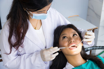 Asian Dentist Checking up on her patient, Female dentist and Female Patient in a Hospital