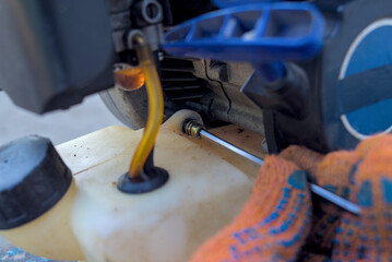 Mechanic unscrews a lawn mower screw