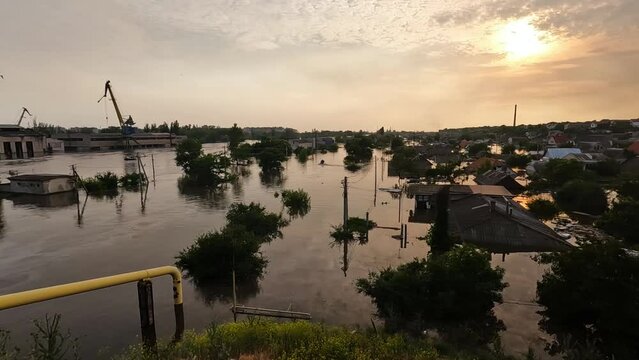 Flooded streets in Kherson town with beautiful sunset at background. Explosion of dam on Dnipro river in city of Novaya Kakhovka. Consequences of detonation of Kakhovka Hydroelectric Power Station