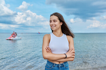 Portrait of smiling teenage girl outdoor on sea background