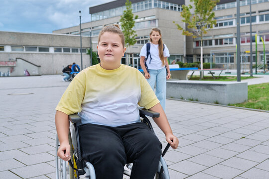 Children go to school, boy 11, 12 years old on wheelchair close-up