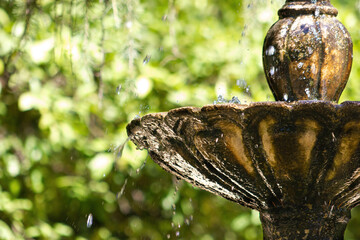 Detail of an old stone fountain with flowing water.
