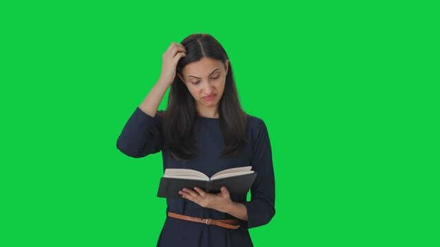 Confused Indian girl reading a book Green screen
