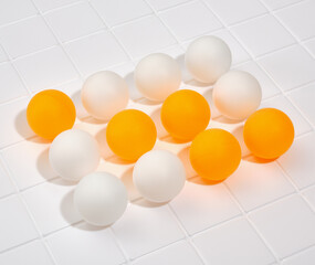 White and yellow table tennis balls lies in row on table. Sport accessories to play games.