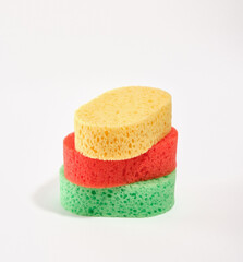 Green, yellow and red shower sponges. Cleanliness, health and body care. Bathroom accessories.